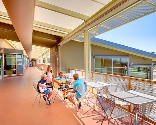 A group of children sitting downplaying guitars at the Redding School of the Arts.