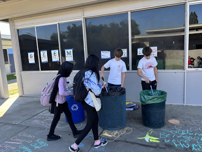 Students participating in sorting waste at their school trash cans.