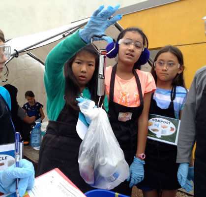 Students weighing recyclable trash.