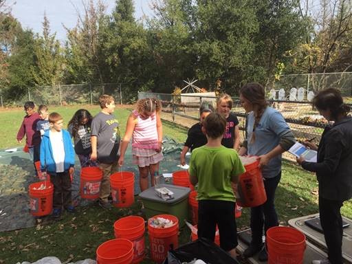 Students conduct a waste audit at their school and separate lunchtime waste into compost, liquid, recyclable, and landfill bins.