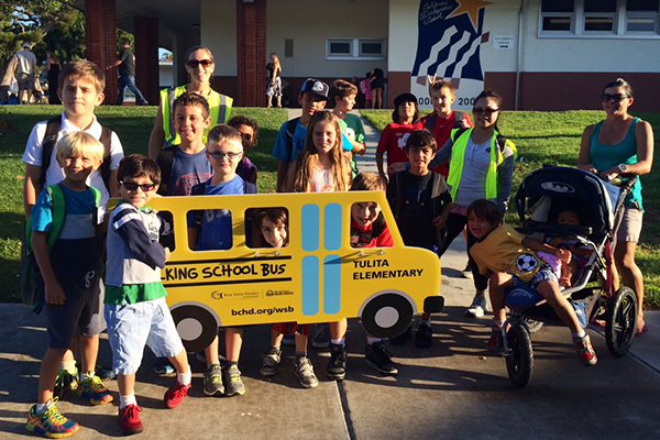 Picture of Redondo Beach Unified School students with a school bus sign.