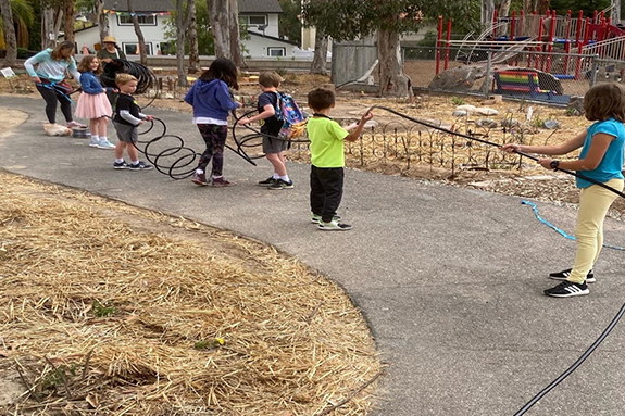 Picture of Santiago STEAM Magnet Elementary School students holding a drip water hose while their teacher extends the length