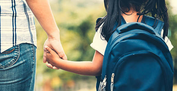 Parent holding a childs hand.